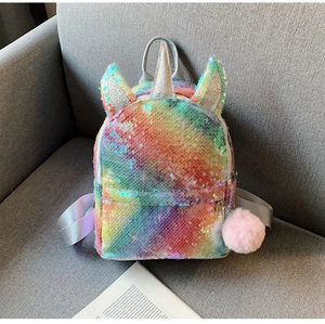Close-up of rainbow sequin unicorn backpack with pink pompom charm and shiny glitter texture