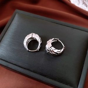Detailed view of silver U-shaped hoop earrings with unique wrinkled metal texture