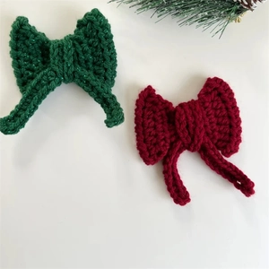 Handmade crochet Christmas bows in red and green yarn for festive tree decoration