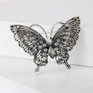 Macro shot of vintage silver butterfly brooch with dark grey rhinestone wing detailing