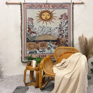 Bohemian tarot sun tapestry with cotton linen texture and fringe detail on white wall