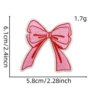 Close-up of pink bow embroidery patch showing fine thread texture on white background