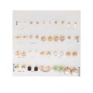 Detailed view of 20 pairs earring set showing heart, pearl, and floral gold designs