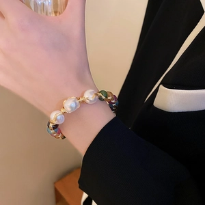 Detail of baroque pearl and gemstone cuff bracelet handcrafted with gold wire on wrist