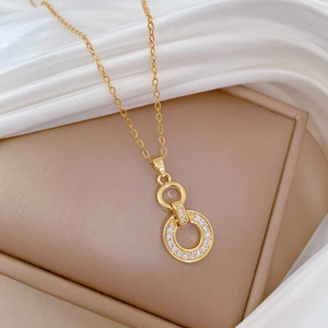 Close-up of interlocking gold rings pendant with pavé set crystals on luxury silk fabric