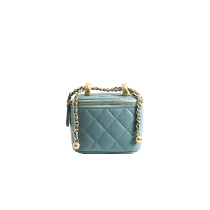 Macro shot of light blue quilted leather bag with golden chain handle and ball detail