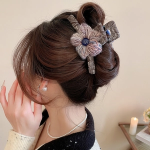Detail of plaid fabric hair claw clip with handmade knit flower and blue bead accent