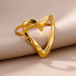 Macro side view of hollow heart ring with gold lava texture on beige silk background
