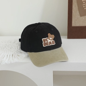 Détail d'une casquette vintage pour enfants avec broderie d'ours et design bicolore