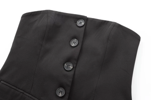 Détail de quatre boutons marbrés sur un blazer noir ajusté en tissu tissé de haute qualité