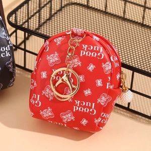 Red mini coin purse with Good Luck tiger print and pearl charm on a beige surface