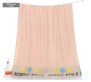 Detailed view of pink cotton bath towel with Nordic style geometric diamond patterns