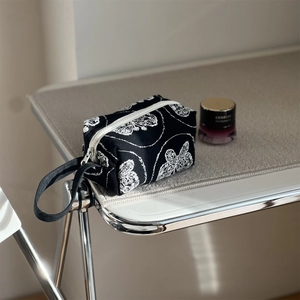 Artistic black canvas handbag with white butterfly embroidery and a sturdy zipper closure