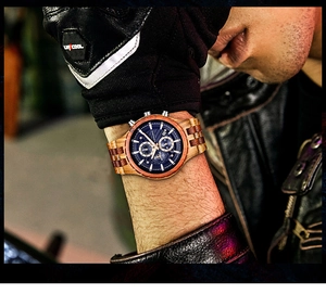 Montre homme en bois avec cadran bleu porté par un mannequin en veste de cuir noir