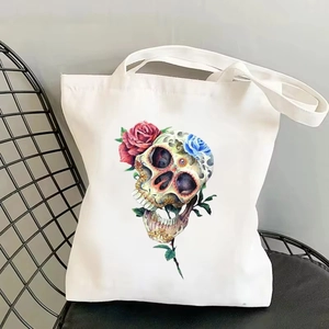 Detail of canvas tote bag with skull and floral print on a chair in a bright setting