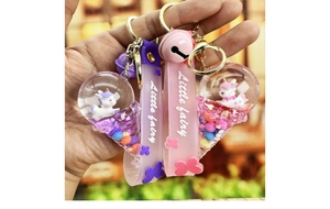 Detail of cute floating unicorn keychain with colorful liquid and pink silicone strap