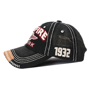 Détail de casquette baseball en denim noir avec broderie FIRE et coutures contrastées