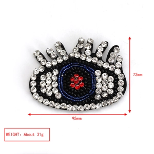 Detail showing embroidered evil eye brooch dimensions 95x72mm and 31g weight