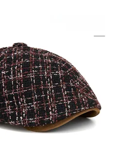 Close-up of tricolor tweed newsboy cap featuring a foldable brown suede brim