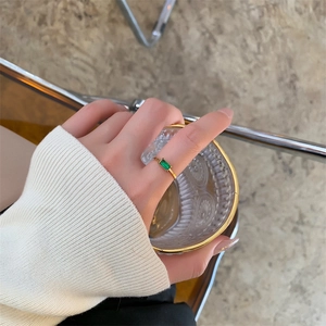Close-up of 18K gold plated ring with emerald green square stone on woman's hand