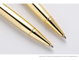 Macro detail of gold metal ballpoint pen tips with polished finish and smooth ink flow