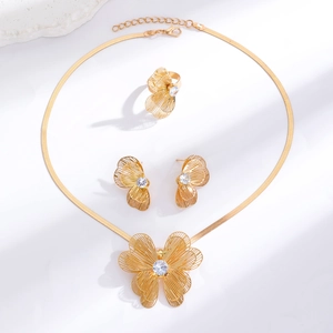 Macro detail of gold plated hollow butterfly jewelry set with white crystal inlays