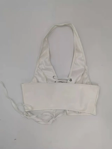 Detail of white PU leather halter top featuring cross-tie back and metallic eyelets
