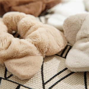 Detailed view of the soft plush texture of beige and light brown elastic scrunchies