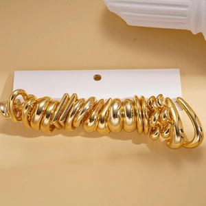 Set of minimalist glossy golden geometric earrings presented on a display card