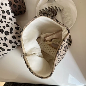 Vue détaillée d'une trousse de maquillage en velours léopard avec fermeture et doublure