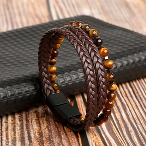 Dettaglio del bracciale multistrato da uomo in pelle intrecciata marrone e occhio di tigre