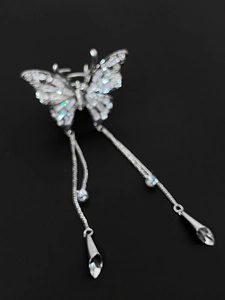 Detail view of butterfly hair clip with sparkling rhinestones and elegant long tassels