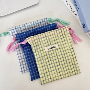 Flat lay of plaid cotton drawstring storage bags in yellow and blue checkered patterns