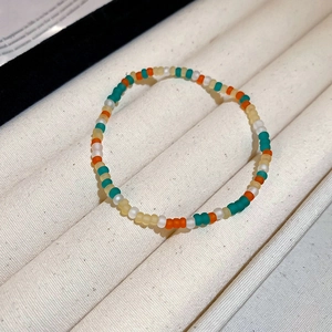 Detail of colorful matte beaded bracelet set with high-quality handmade texture on fabric