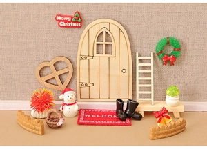 Detailed view of a miniature Christmas elf door set with snowman and wooden accessories