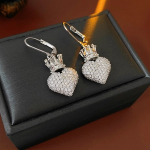 Détail de boucles d'oreilles cœur couronne en argent avec zircons sur une boîte à bijoux