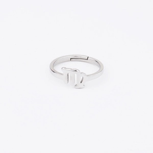 Macro shot of silver Virgo zodiac symbol on polished stainless steel open ring detail
