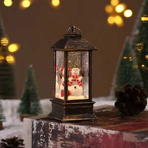 Close-up of bronze Christmas lantern featuring a snowman scene and festive glitter