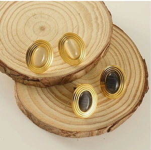 Détails de boucles d'oreilles ovales dorées avec pierres œil-de-chat beige et gris foncé
