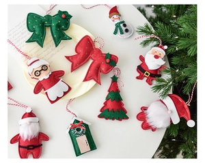 Detailed close-up of festive felt Christmas ornaments including Santa, snowman and bows