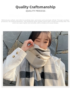 Detailed texture of thick grey and black plaid cashmere-like scarf worn by a model