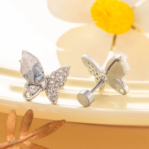 Silver butterfly crystal stud earrings with screw back on a floral decorative background