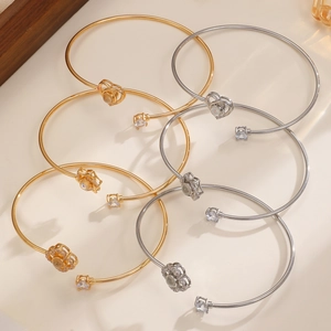Détails macro de divers bracelets ouverts en or et argent avec cœurs et fleurs projetés