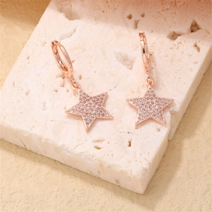 Elegant rose gold star hoop earrings with shimmering cubic zirconia on stone background