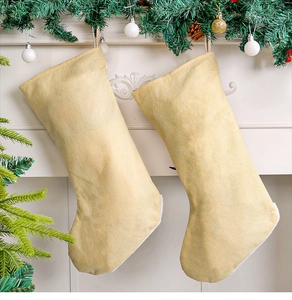 Dettaglio delle calze di Natale in feltro beige appese a un caminetto decorato