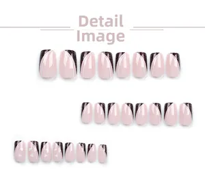 Detail of square pink and black glitter press-on nails with white heart patterns