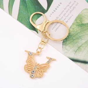 Close-up of golden butterfly keychain with intricate hollow design and sparkling rhinestones