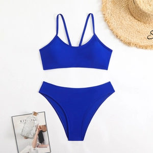 Flat lay view of Klein blue bikini set with top and bottoms on white background