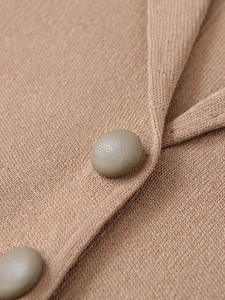 Close-up of brown knit fabric texture with vintage style grey-green buttons on a cardigan