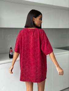 Détail d'un t-shirt rouge oversize pour femme avec un motif de cœur texturé subtil